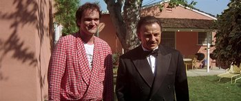 Movie still from “Pulp Fiction” (1994), directed by Quentin Tarantino – A man and a woman standing next to each other outside; Medium shot, Low angle