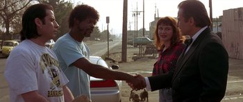 Movie still from “Pulp Fiction” (1994), directed by Quentin Tarantino – A man and a woman shaking hands on the side of the road; Medium shot, Over the shoulder angle