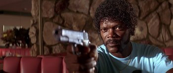 Movie still from “Pulp Fiction” (1994), directed by Quentin Tarantino – A man with a gun in his hand; Close Up shot, Low angle