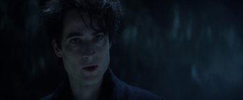 Movie still from “The Sandman” (2022), created by Neil Gaiman – A person wearing a black jacket; Close Up shot, Over the shoulder angle