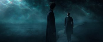 Movie still from “The Sandman” (2022), created by Neil Gaiman – Two men are standing on a dock in the dark; Wide shot, Over the shoulder angle