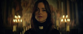 Movie still from “The Sandman” (2022), created by Neil Gaiman – A person wearing a priest's collar; Close Up shot, Low angle