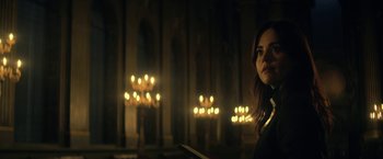 Movie still from “The Sandman” (2022), created by Neil Gaiman – A woman standing in front of a group of candles; Close Up shot, Low angle