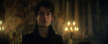 Movie still from “The Sandman” (2022), created by Neil Gaiman – A young man in a black jacket is looking at the camera; Close Up shot, Low angle