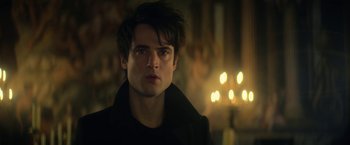 Movie still from “The Sandman” (2022), created by Neil Gaiman – A man with a black jacket is looking into the distance; Close Up shot, Over the shoulder angle