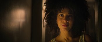 Movie still from “The Sandman” (2022), created by Neil Gaiman – A person with curly hair smiling; Close Up shot, Low angle