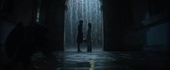 Movie still from “The Sandman” (2022), created by Neil Gaiman – Two people standing in front of a waterfall at night; Wide shot, Low angle