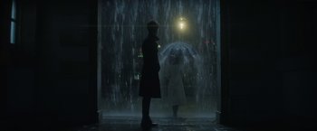 Movie still from “The Sandman” (2022), created by Neil Gaiman – A man and a woman under an umbrella in the rain; Wide shot, Over the shoulder angle