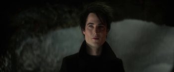Movie still from “The Sandman” (2022), created by Neil Gaiman – A man with a black jacket and a black shirt; Close Up shot, Over the shoulder angle