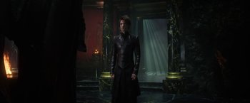 Movie still from “The Sandman” (2022), created by Neil Gaiman – A man in a black leather jacket standing in a room; Medium shot, Over the shoulder angle
