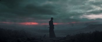 Movie still from “The Sandman” (2022), created by Neil Gaiman – A man standing on a beach with a sword; Wide shot, Over the shoulder angle