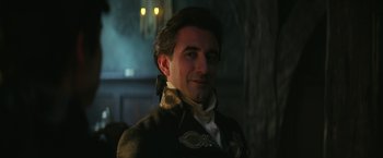 Movie still from “The Sandman” (2022), created by Neil Gaiman – A person wearing a suit and tie; Close Up shot, Over the shoulder angle