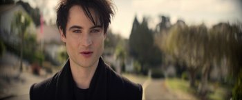 Movie still from “The Sandman” (2022), created by Neil Gaiman – A person wearing a black jacket; Close Up shot, Over the shoulder angle