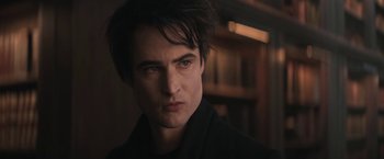 Movie still from “The Sandman” (2022), created by Neil Gaiman – A person wearing a black shirt; Close Up shot, Over the shoulder angle