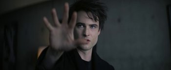 Movie still from “The Sandman” (2022), created by Neil Gaiman – A young man making a stop gesture with his hand; Close Up shot, Over the shoulder angle