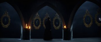 Movie still from “The Sandman” (2022), created by Neil Gaiman – A man in a black robe walking in front of three mirrors; Wide shot, Over the shoulder angle