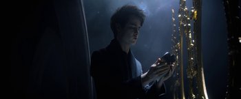 Movie still from “The Sandman” (2022), created by Neil Gaiman – A man looking at his cell phone in the dark; Medium shot, High angle
