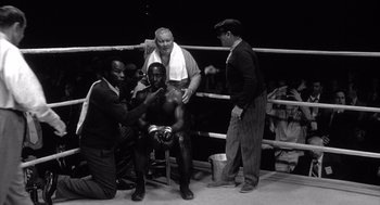 Movie still from “Raging Bull” (1980), directed by Martin Scorsese – An old black and white photo of a man in a boxing ring; Medium shot, High angle