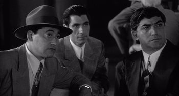 Movie still from “Raging Bull” (1980), directed by Martin Scorsese – A group of men sitting next to each other in a room; Medium shot, Over the shoulder angle