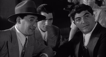 Movie still from “Raging Bull” (1980), directed by Martin Scorsese – A group of men in suits and hats posing for a picture; Medium shot, Low angle