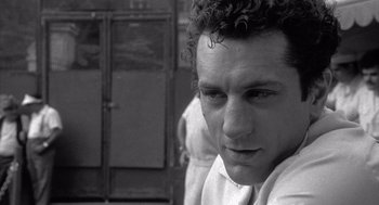 Movie still from “Raging Bull” (1980), directed by Martin Scorsese – Black and white photograph of a young man in front of lockers; Close Up shot, Over the shoulder angle