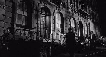 Movie still from “Raging Bull” (1980), directed by Martin Scorsese – A man standing on the side of a building next to a fire hydrant; Wide shot, Low angle