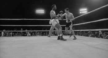 Movie still from “Raging Bull” (1980), directed by Martin Scorsese – Two men in a boxing ring fighting in front of a crowd of people; Wide shot, High angle