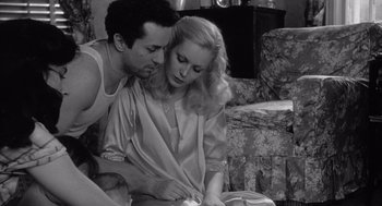 Movie still from “Raging Bull” (1980), directed by Martin Scorsese – A man and a woman sitting on a couch looking at a book; Medium shot, High angle