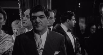 Movie still from “Raging Bull” (1980), directed by Martin Scorsese – Black and white photograph of men in tuxedos; Medium shot, Over the shoulder angle
