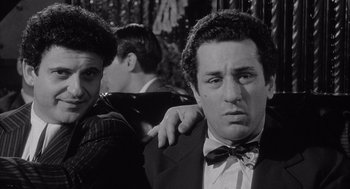 Movie still from “Raging Bull” (1980), directed by Martin Scorsese – A man in a suit and bow tie standing next to another man; Close Up shot, Low angle