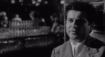 Movie still from “Raging Bull” (1980), directed by Martin Scorsese – Black and white photograph of a man in front of a bar; Close Up shot, Low angle