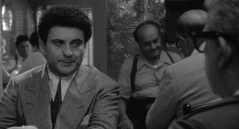 Movie still from “Raging Bull” (1980), directed by Martin Scorsese – A black - and - white photo of three men in suits; Medium shot, Over the shoulder angle