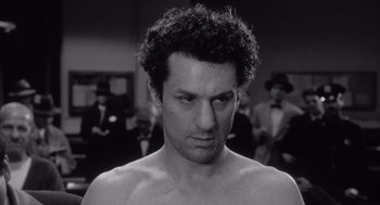 Movie still from “Raging Bull” (1980), directed by Martin Scorsese – Black and white photograph of a man in a crowd; Close Up shot, Low angle