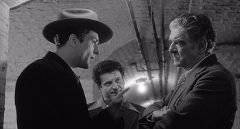 Movie still from “Raging Bull” (1980), directed by Martin Scorsese – A group of men standing next to each other in a room; Medium shot, Low angle