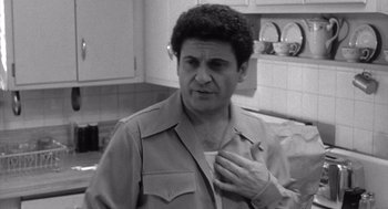 Movie still from “Raging Bull” (1980), directed by Martin Scorsese – A black - and - white photo of a man holding his hand on his chest; Medium shot, Over the shoulder angle