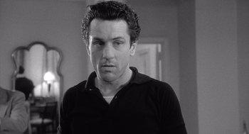 Movie still from “Raging Bull” (1980), directed by Martin Scorsese – Black and white photograph of a man in a black shirt; Close Up shot, Low angle