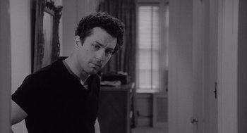 Movie still from “Raging Bull” (1980), directed by Martin Scorsese – Black and white photograph of a man in a black shirt; Close Up shot, Over the shoulder angle