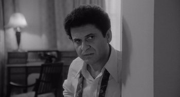 Movie still from “Raging Bull” (1980), directed by Martin Scorsese – Black and white photograph of a man leaning against a wall; Close Up shot, High angle
