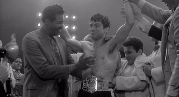 Movie still from “Raging Bull” (1980), directed by Martin Scorsese – A black - and - white photo of a man in a boxing ring; Medium shot, Low angle