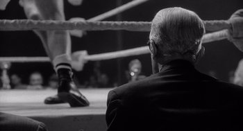 Movie still from “Raging Bull” (1980), directed by Martin Scorsese – An older man sitting in a boxing ring; Close Up shot, Low angle