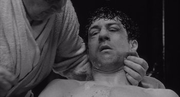 Movie still from “Raging Bull” (1980), directed by Martin Scorsese – A man with a towel on his head and a towel around his neck; Close Up shot, Low angle