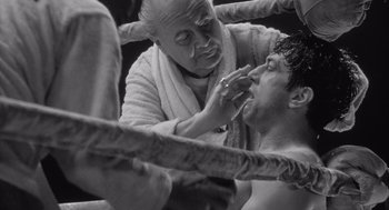 Movie still from “Raging Bull” (1980), directed by Martin Scorsese – An old man and a young man in a boxing ring getting ready for a fight; Close Up shot, Low angle