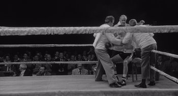 Movie still from “Raging Bull” (1980), directed by Martin Scorsese – Two men in a boxing ring fighting each other in front of a crowd; Wide shot, High angle