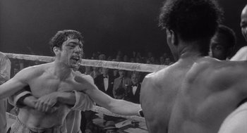 Movie still from “Raging Bull” (1980), directed by Martin Scorsese – Two men in a boxing ring fighting in front of an audience; Close Up shot, Low angle