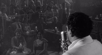 Movie still from “Raging Bull” (1980), directed by Martin Scorsese – A man holding a microphone in front of an audience; Wide shot, High angle
