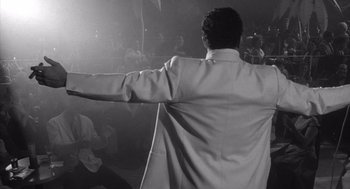 Movie still from “Raging Bull” (1980), directed by Martin Scorsese – A black and white photo of a man with his arms outstretched; Medium shot, Over the shoulder angle