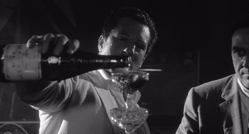Movie still from “Raging Bull” (1980), directed by Martin Scorsese – A man pouring a drink into a wine glass; Close Up shot, Low angle