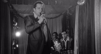 Movie still from “Raging Bull” (1980), directed by Martin Scorsese – A black and white photo of a man singing into a microphone; Medium shot, Low angle