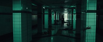 Movie still from “The Silence” (2019), directed by John R. Leonetti – A dark hallway with pillars and lights in it; Extreme Wide shot, High angle