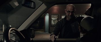 Movie still from “The Silence” (2019), directed by John R. Leonetti – A man sitting in the passenger seat of a car looking out of the window; Close Up shot, Over the shoulder angle